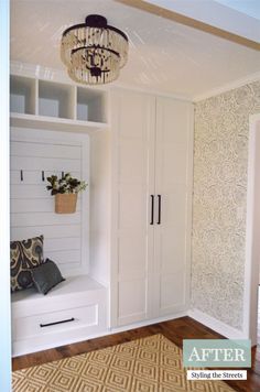 a room with white cabinets and a chandelier hanging from the ceiling