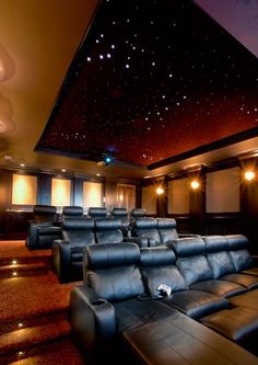 an empty theater with blue leather seats and stars in the sky above it, at night