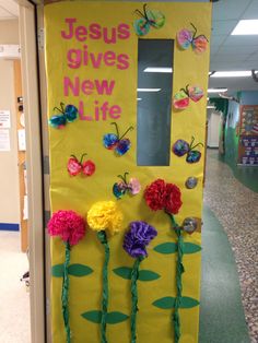 a bulletin board with flowers and butterflies on it in an office hallway for jesus gives new life