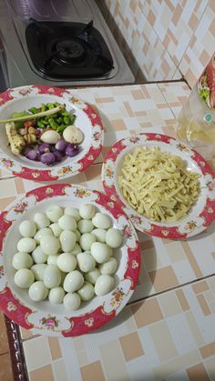 three plates filled with different types of food on a kitchen counter next to a stove