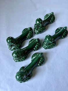 four green glass knobs sitting on top of a white table