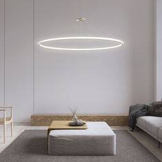 a living room with a couch, coffee table and lights hanging from the ceiling above it