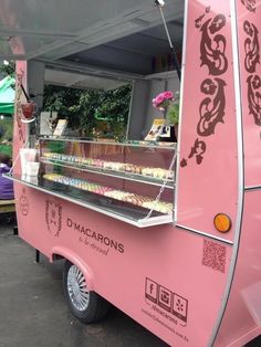 a pink food truck parked in front of a building