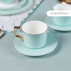 there is a blue cup and saucer on the table with silverware in front of it