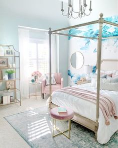 a bed room with a neatly made bed and a chandelier hanging from the ceiling