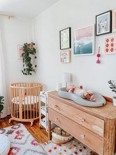 a baby crib in the corner of a room with pictures hanging on the wall