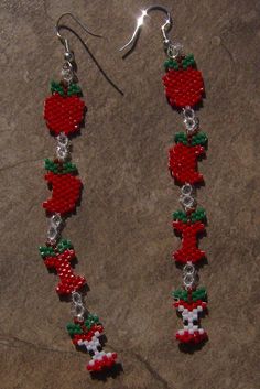 red and green beaded apple dangle earrings with silver hooks on grey stone background