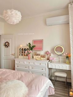 a bedroom with pink and white decor on the walls, dressers and bedding