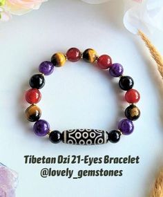 Here is a listing for a colorful Tibetan Dzi 21 - Eyes gemstone bracelet. This Feng Shui amulet bracelet is made of natural round gemstones in 10mm bead size, like: amethyst, carnelian, tiger's eye, black tourmaline, black onyx, and black agate barrel Dzi bead - 21 eyes. Materials used: 10mm round tumbled beads of amethyst, tiger's eye, carnelian, black tourmaline, 8mm beads of black onyx (only in M and L sizes of bracelet), golden hematite spacers and black agate Dzi bead 21 eyes of 28mm. Bracelet Gemstone, Black Agate, Tiger's Eye, Black Tourmaline, Eye Black, Gemstone Bracelet