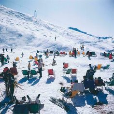 a group of people sitting on top of a snow covered slope