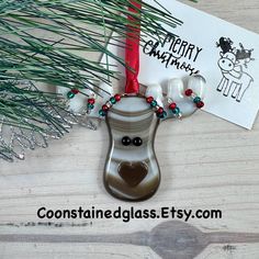 a reindeer ornament hanging from a christmas tree next to a card with merry christmas written on it