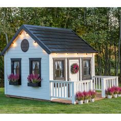 a small blue and white house sitting on top of a lush green field