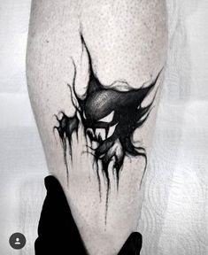 a black and white photo of a man's leg with an evil face on it