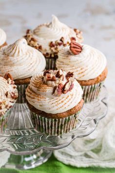 cupcakes with frosting and pecans on a glass platter, ready to be eaten