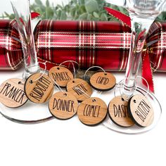 wine glasses with wooden tags on them sitting next to plaid wrapped presents