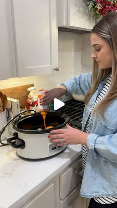 a woman is cooking in the kitchen with an electric pressure cooker