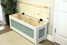 a white bench with two wooden boxes on it's sides and a potted plant in the background