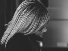 black and white photograph of a woman talking on a cell phone with her hair blowing in the wind