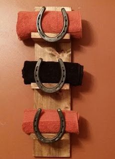 three pairs of horseshoes are mounted to a wooden board with two towels on it