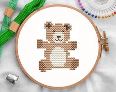 a cross stitch bear sitting on top of a table