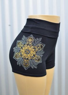 Crystal Mandala High Waisted Hot Shorts - Glow in the Dark Sacred Geometry Yoga ShortsThese comfortable and stylish black high waisted hot shorts features a glow in the dark and metallic gold screen print of my hand drawn Crystal Mandala. This original design also includes a metallic gold print of my simple Metatron's Cube, which I made specifically to layer and align with the geometry of my more detailed Crystal Mandala. This gold layer also includes the Platonic Solids and the Seed of Life in Black Short Length Rave Bottoms, Stretch Rave Shorts, Stretch Festival Bottoms, Fitted Rave Shorts, Fitted Rave Bottoms With Built-in Shorts, Rave Style Festival Shorts, Crystal Mandala, Metatron's Cube, Platonic Solid