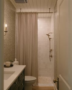 a bathroom with a shower, toilet and sink