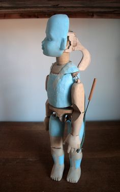 a small blue and white toy sitting on top of a wooden table next to a wall