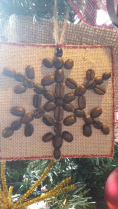 an ornament hanging from a christmas tree decorated with coffee beans and pine cones