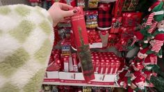 a person is holding a red box in front of christmas decorations