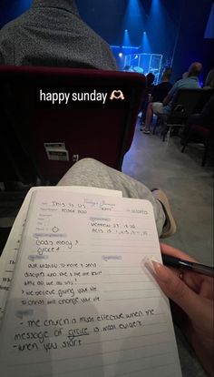 someone is sitting in front of a laptop and holding a piece of paper with the words happy sunday written on it