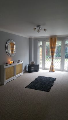 a living room filled with furniture and a large window covered in yellow drapes