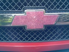 the front grille of a chevrolet car with pink crystals