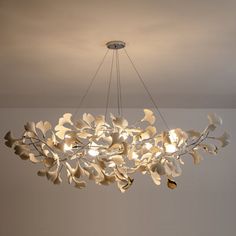 a large chandelier with white flowers hanging from it's center point in a room