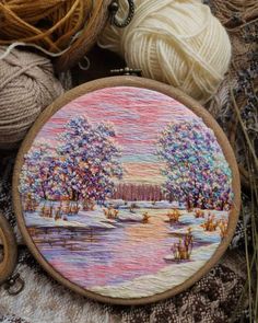 a close up of a embroidery on a table next to yarn and balls of thread