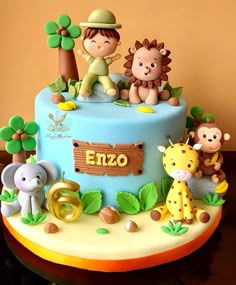 a blue cake with animals on it and the number six is for ezo