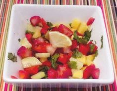 a white bowl filled with fruit on top of a table