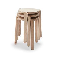 three wooden stools stacked on top of each other in front of a white background