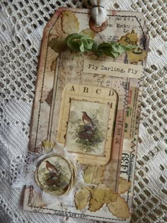 an altered photograph of a bird on a piece of paper with leaves and ribbons attached to it