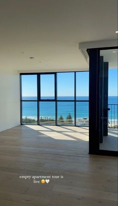 an empty room with large windows overlooking the ocean