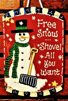 a wooden sign with a snowman holding a shovel and saying free snow shovel all you want