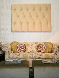 a living room with couches and tables in front of a painting on the wall