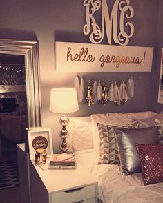 a white bed topped with pillows next to a night stand and lamp on top of a dresser