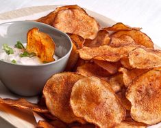 some potato chips on a plate with dip