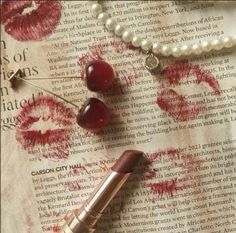 lipstick and pearls on top of an old book