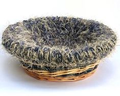 a basket with some kind of material in it on a white surface, that looks like something out of the ground