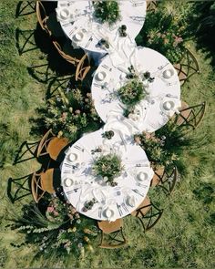 an overhead view of two tables and chairs with white tablecloths on them in the grass