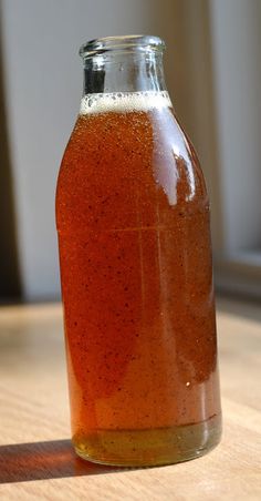 a bottle filled with liquid sitting on top of a wooden table