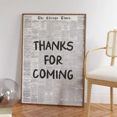 a framed newspaper with the words thanks for coming printed on it next to a chair