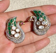 Sabyasachi-inspired Emerald Doublet Polki earrings crafted with precision, they showcase the exquisite charm of Uncut Polki studs, complemented by the brilliance of Moissanite diamonds. Embellished with traditional Jadau Kundan detailing, these earrings capture the essence of Indian craftsmanship and elegance. Elevate your ensemble with the timeless sophistication of these India earrings, a perfect blend of heritage and contemporary style. *𝐏𝐑𝐎𝐃𝐔𝐂𝐓 𝐃𝐄𝐓𝐀𝐈𝐋* * Material: Brass * Platin Ceremonial Kundan Earrings With Peacock Design, Intricate Temple Jewelry Earrings With American Diamond, American Diamond Temple Jewelry Earrings With Intricate Design, Traditional Cutdana Earrings With American Diamond, Ceremonial Silver Earrings With Stone Work, Traditional Bridal Earrings With Meenakari And American Diamond, Traditional American Diamond Meenakari Bridal Earrings, Meenakari American Diamond Earrings For Diwali, Temple Jewelry Earrings With American Diamond