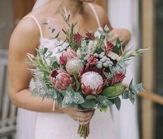 a woman holding a bouquet of flowers in her hands